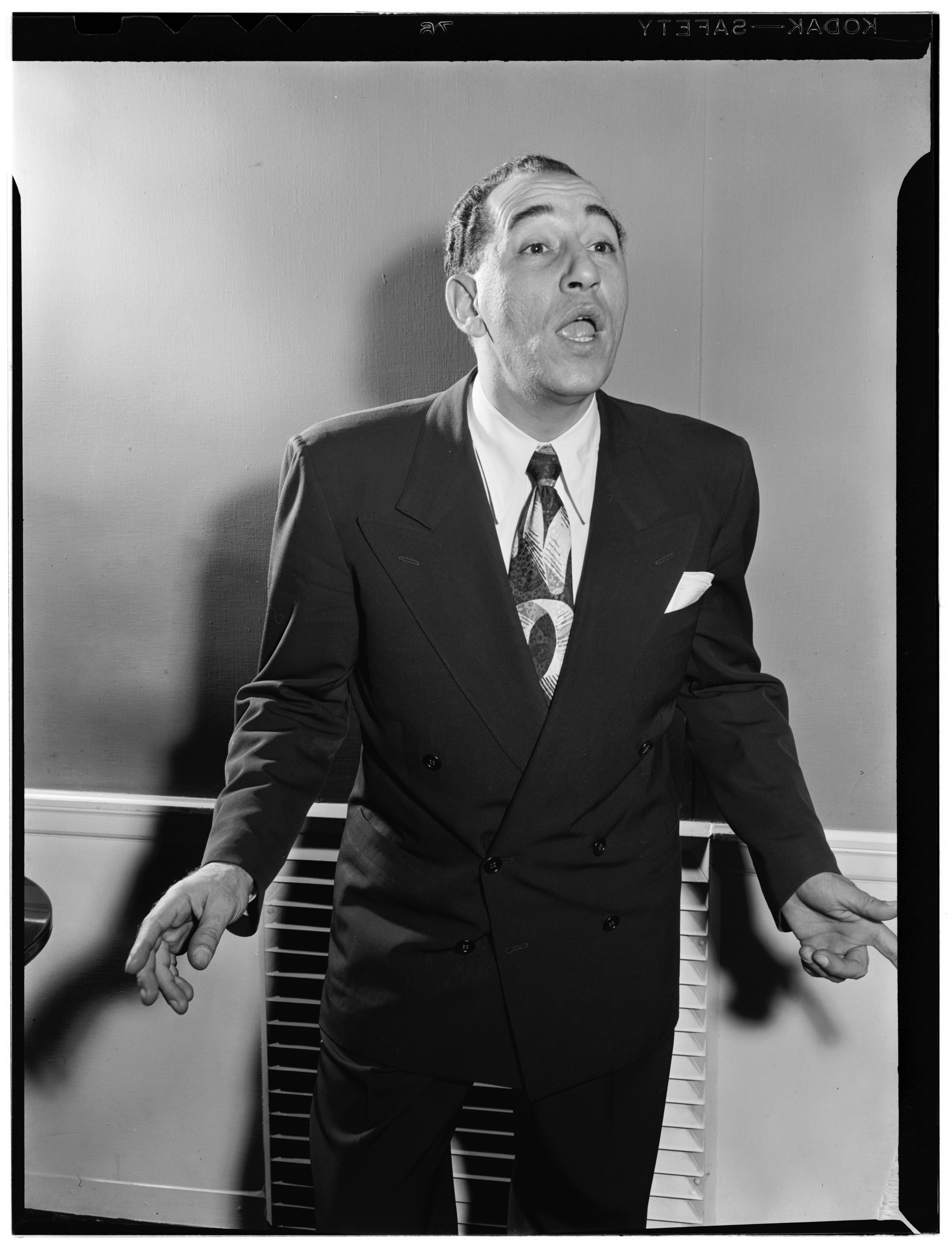 Black-and-white photo of Louis Prima in a dark suit and tie